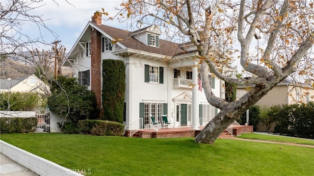 back of property featuring a yard and a balcony