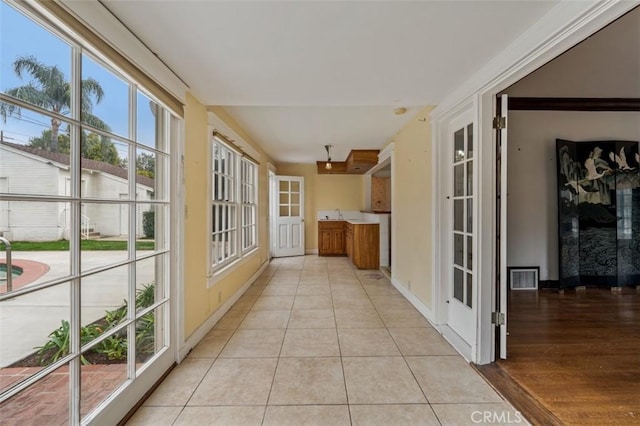 hallway featuring a wealth of natural light and light tile patterned floors