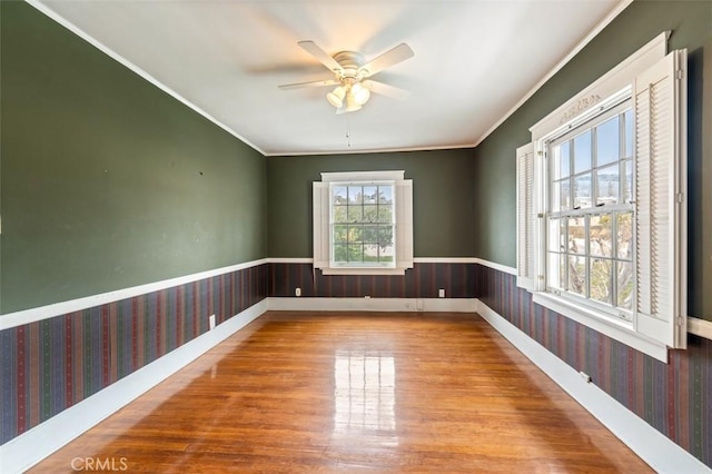 empty room featuring ornamental molding, hardwood / wood-style floors, and ceiling fan