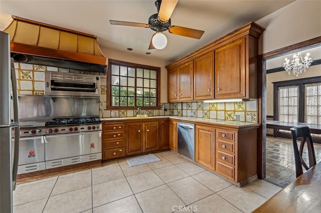 kitchen with stainless steel appliances, light tile patterned flooring, tile counters, and backsplash