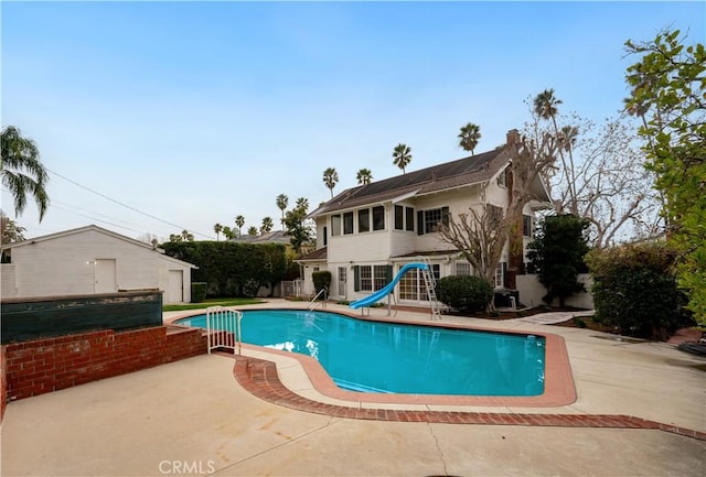 view of pool with a patio and a water slide