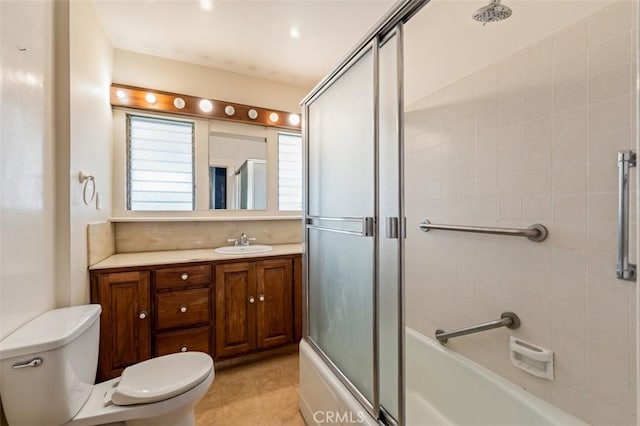 full bathroom featuring enclosed tub / shower combo, vanity, tile patterned floors, and toilet