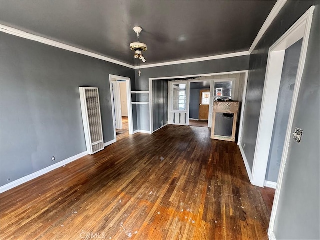 unfurnished living room featuring baseboards, wood-type flooring, and ornamental molding