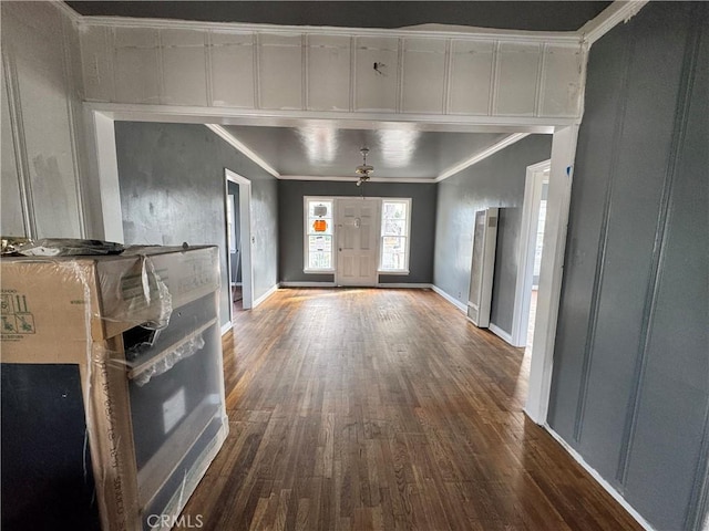 entrance foyer featuring baseboards, dark wood-type flooring, and ornamental molding