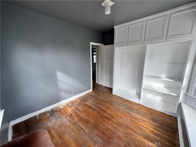 unfurnished bedroom featuring dark hardwood / wood-style flooring and a closet