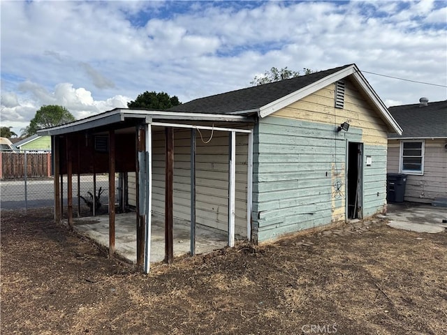 view of outbuilding featuring fence