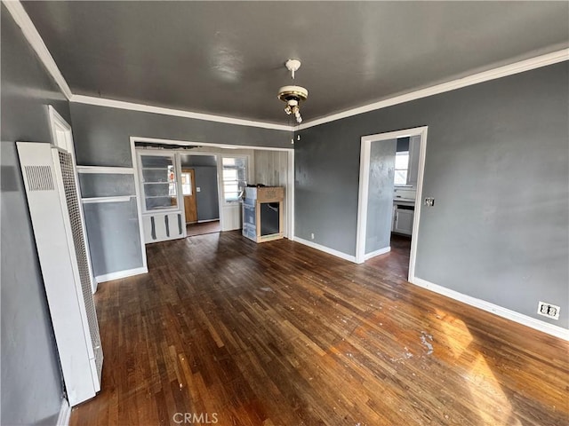 unfurnished living room featuring dark hardwood / wood-style flooring, crown molding, and a wealth of natural light