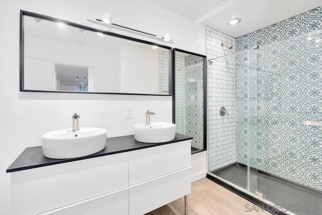 bathroom with vanity, wood-type flooring, and a shower with door