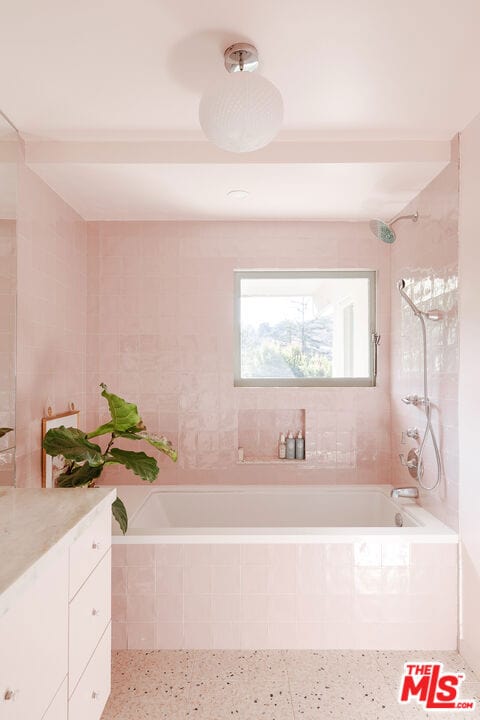 bathroom featuring vanity and tiled shower / bath