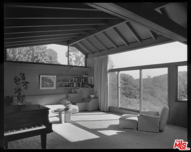 interior space with carpet floors, beam ceiling, and high vaulted ceiling