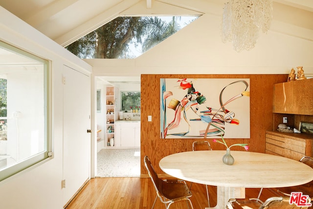 dining room with vaulted ceiling and light wood-type flooring