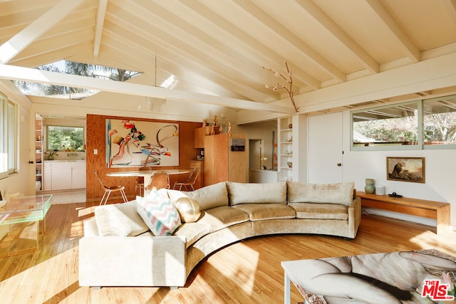 living room with vaulted ceiling with beams, hardwood / wood-style flooring, and built in shelves