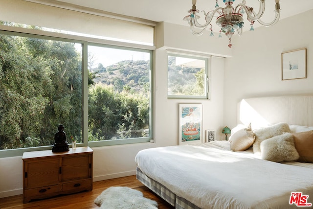 bedroom featuring wood-type flooring and a notable chandelier