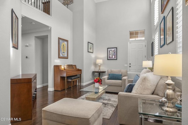 living room featuring a towering ceiling, ornamental molding, and dark hardwood / wood-style floors