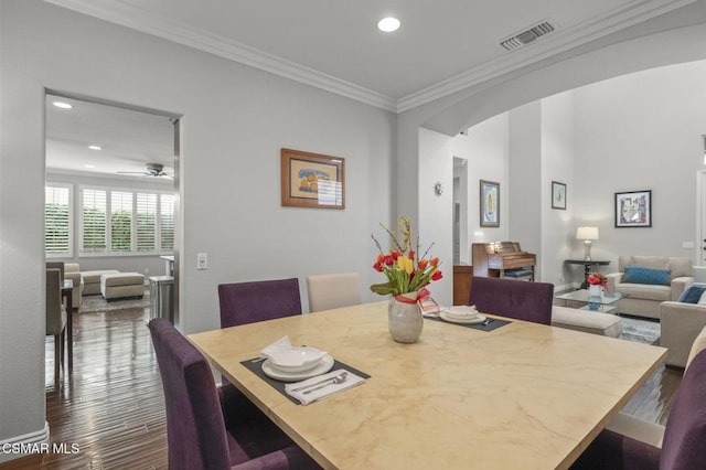 dining space with dark hardwood / wood-style flooring, ornamental molding, and ceiling fan