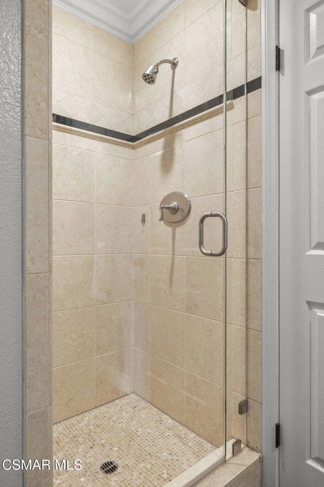 bathroom with crown molding and an enclosed shower