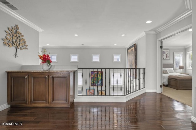 corridor with dark wood-type flooring and crown molding