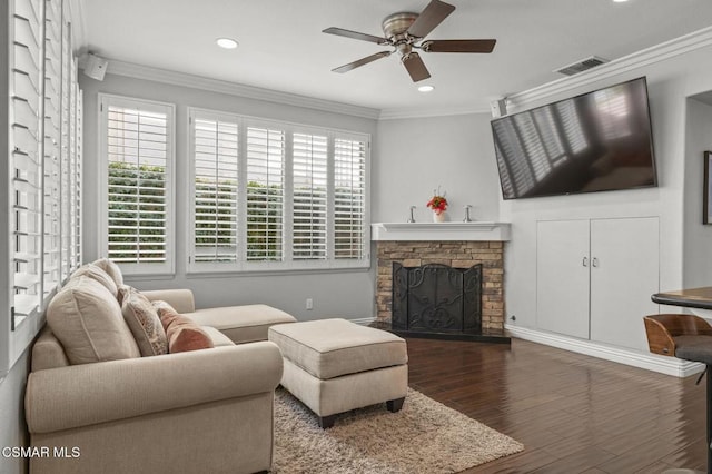 living room with ceiling fan, a fireplace, ornamental molding, and dark hardwood / wood-style floors