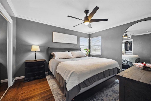 bedroom featuring crown molding, ceiling fan, dark hardwood / wood-style flooring, and a closet