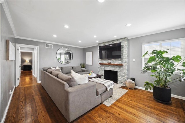 living room featuring crown molding, dark hardwood / wood-style floors, and a stone fireplace