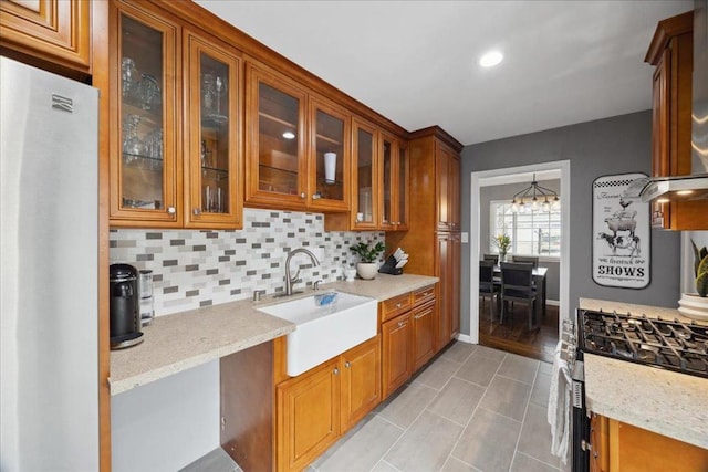 kitchen featuring light tile patterned flooring, sink, light stone counters, tasteful backsplash, and stainless steel appliances