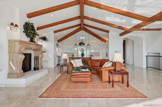 living room with a high end fireplace and vaulted ceiling with beams