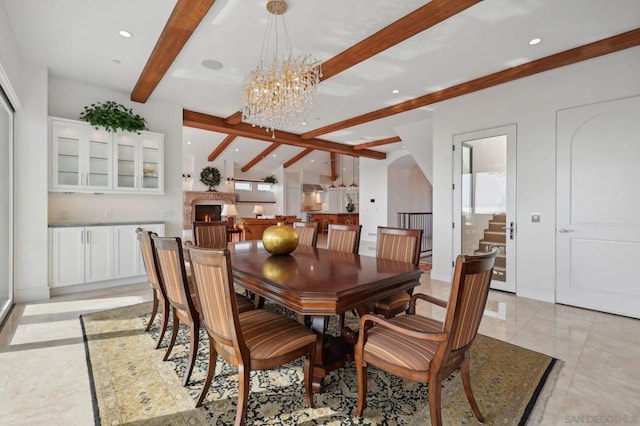 dining area with a chandelier and beam ceiling