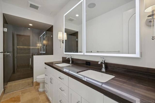 bathroom featuring vanity, toilet, and a shower with door