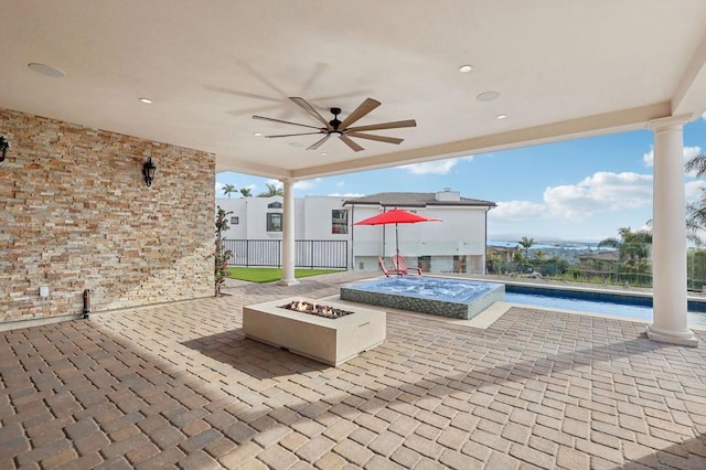 view of patio featuring ceiling fan, an outdoor fire pit, and a swimming pool with hot tub