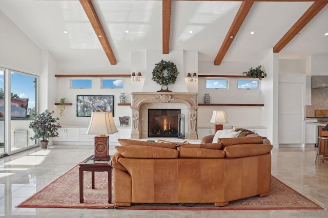 living room with a high end fireplace and beamed ceiling