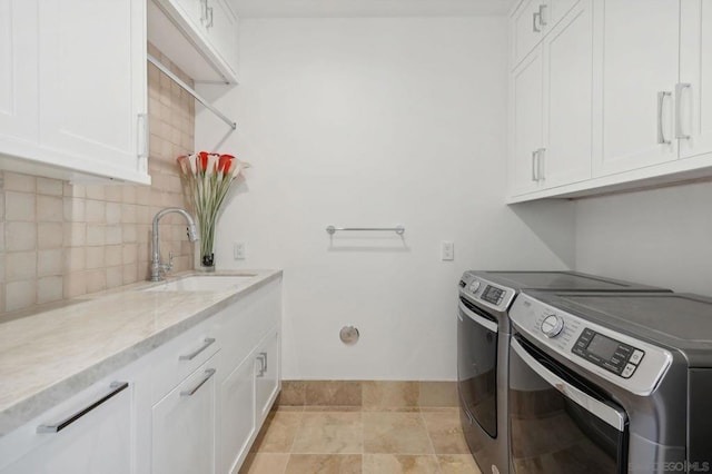 laundry room featuring cabinets, separate washer and dryer, and sink