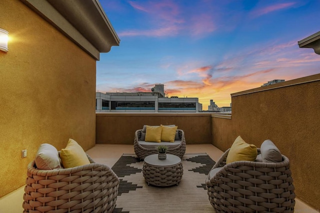 patio terrace at dusk featuring a balcony