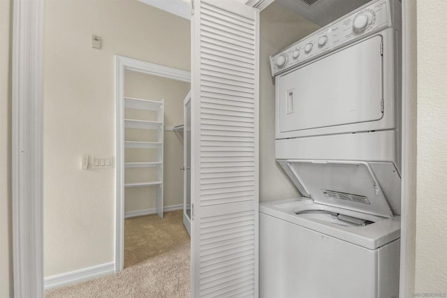 laundry area with light carpet and stacked washer / dryer