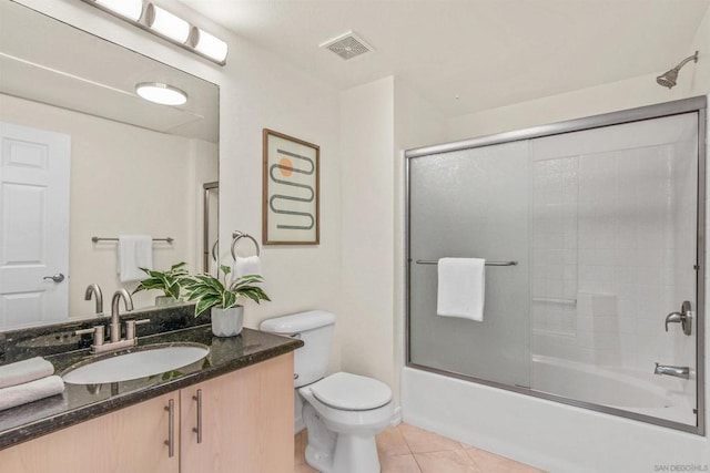 full bathroom featuring tile patterned flooring, vanity, toilet, and combined bath / shower with glass door