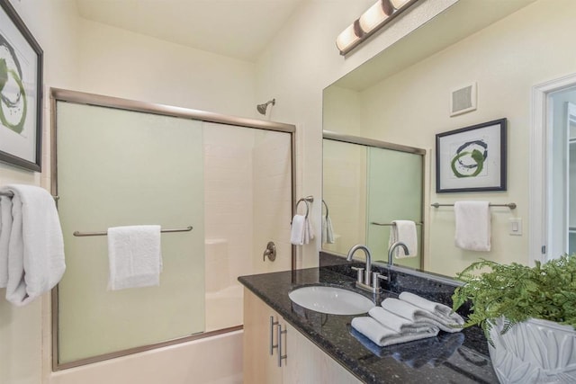 bathroom with vanity, a skylight, and enclosed tub / shower combo