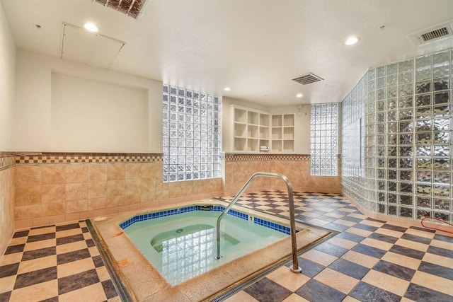 view of swimming pool with an indoor hot tub