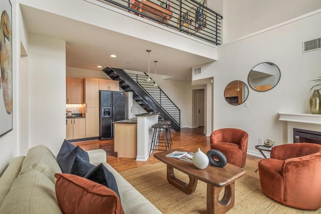 living room featuring a towering ceiling and light hardwood / wood-style flooring