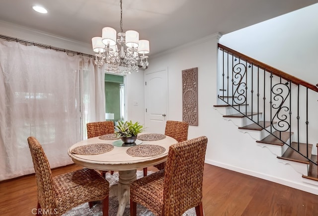 dining room with crown molding, hardwood / wood-style floors, and a notable chandelier