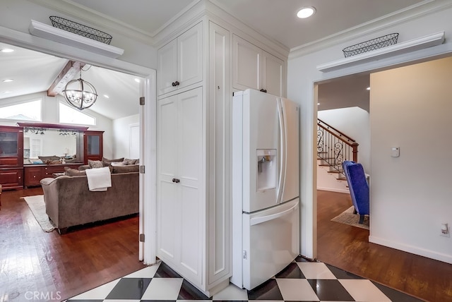 kitchen featuring white cabinetry, white refrigerator with ice dispenser, ornamental molding, and a notable chandelier