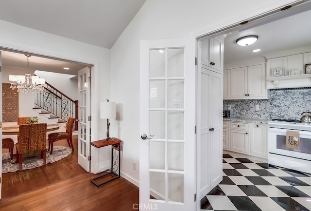 kitchen with white electric range, white cabinetry, light stone counters, tasteful backsplash, and vaulted ceiling