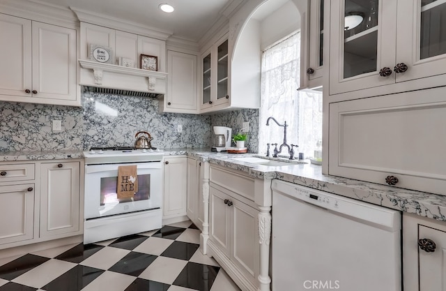 kitchen featuring tasteful backsplash, white cabinetry, sink, light stone countertops, and white appliances