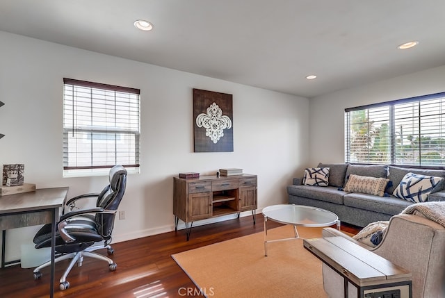 living room with dark wood-type flooring and a healthy amount of sunlight