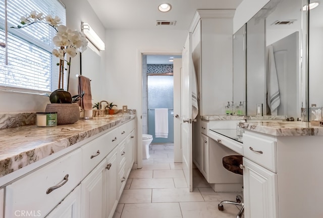 bathroom featuring tile patterned flooring, vanity, an enclosed shower, and toilet