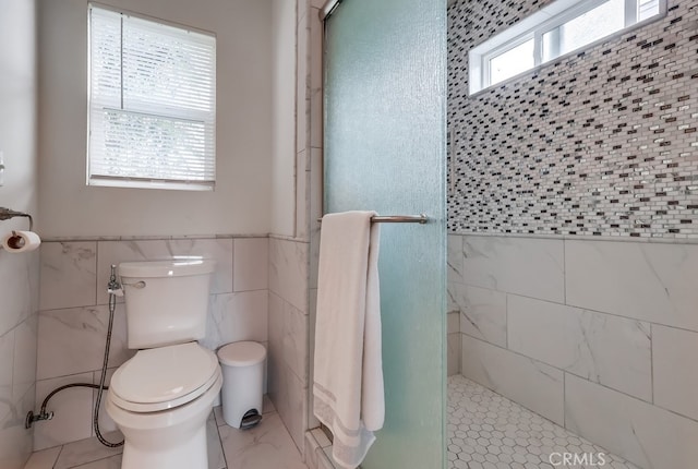 bathroom featuring tile walls, toilet, and walk in shower