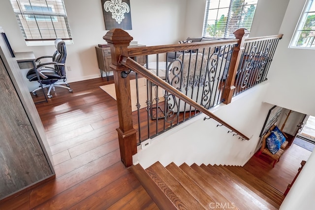 stairs with wood-type flooring and a chandelier