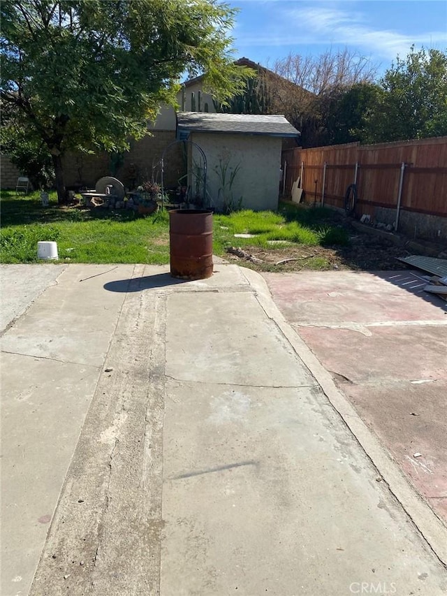 view of patio / terrace with fence and an outdoor structure