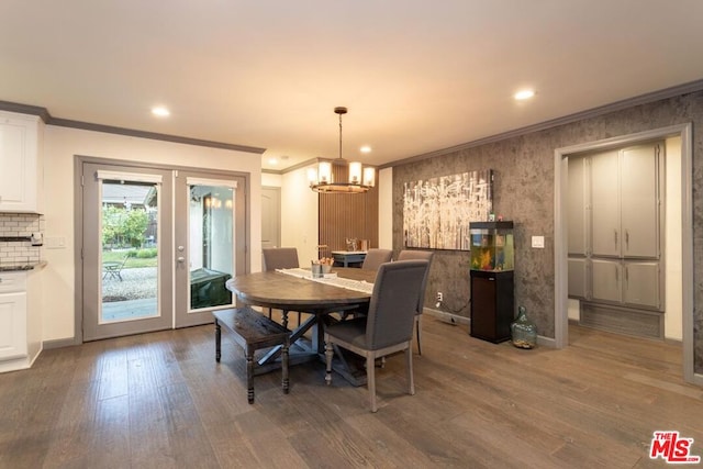 dining room featuring a notable chandelier, dark wood-type flooring, ornamental molding, and french doors