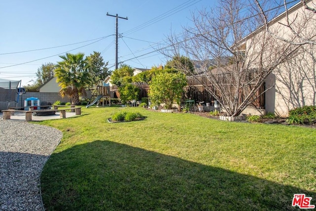 view of yard featuring a trampoline and a playground