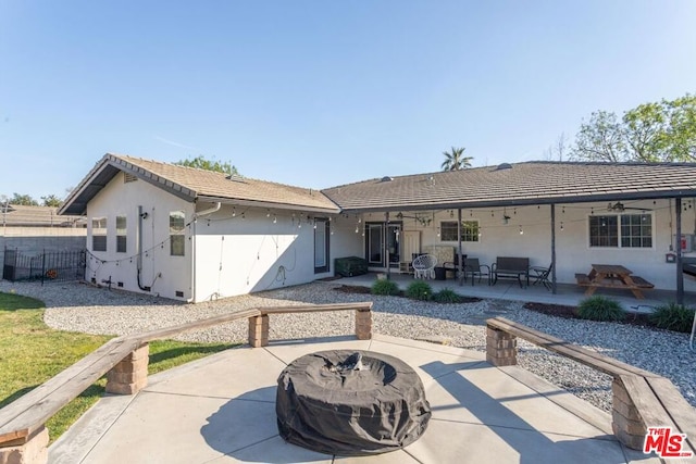 rear view of house with ceiling fan, an outdoor fire pit, and a patio