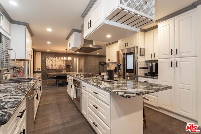 kitchen featuring sink, dark stone countertops, a breakfast bar area, white cabinets, and stainless steel appliances